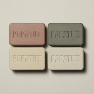 Flat lay image of four PAPATUI™ Enriching Big Bar Soaps in assorted scents Lush Coconut, Sandalwood Suede, Cedar Sport, Vanilla Shea arranged neatly in a grid on a light beige background. All bars are embossed with PAPATUI™ logo.