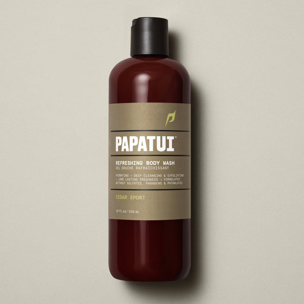 PAPATUI™ Cedar Sport Refreshing Body Wash 18 fl oz bottle, designed for men seeking deep cleansing and long-lasting freshness. The amber bottle features a minimalist beige label with black flip cap, highlighting key benefits including sulfate-free, paraben-free, and phthalate-free formulas, placed against a clean beige backdrop.