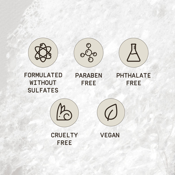 A smooth, creamy background highlighting six circular icons that represent key benefits of PAPATUI™ Enhancing Tattoo Balm. Each icon features a minimalist design with bold text beneath: 'Formulated Without Sulfates' (atomic structure icon), 'Paraben Free' (molecular structure icon), 'Phthalate Free' (lab flask icon), 'Cruelty Free' (bunny icon), 'Vegan' (leaf icon), and 'Fragrance Free' (perfume bottle icon). The soft, spread balm texture reinforces the product’s nourishing, clean, and skin-friendly formula