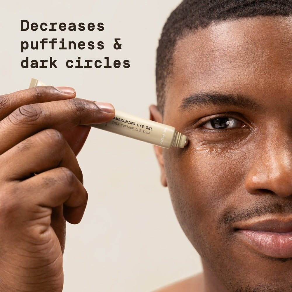 Man applying PAPATUI Awakening Eye Gel against a neutral background with text overlay that reads "Decreases puffiness & dark circles"