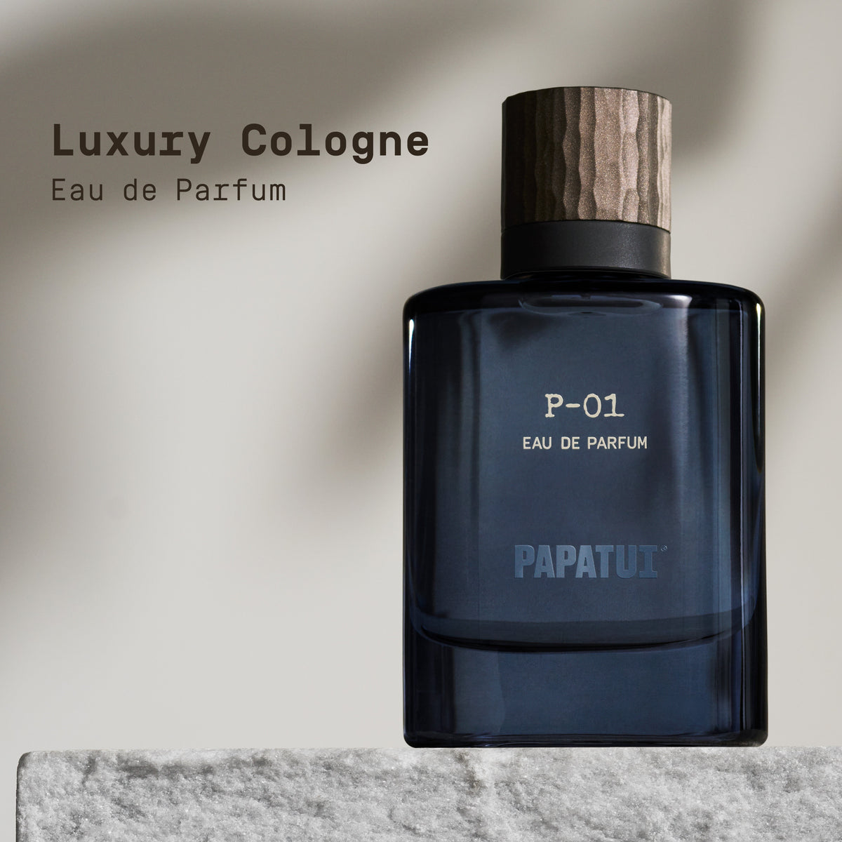 Blue perfume bottle labeled 'P-01 Eau de Parfum' by 'PAPATUI' on a marble surface with a neutral background with text overlay that reads "Luxury Cologne Eau de Parfum"