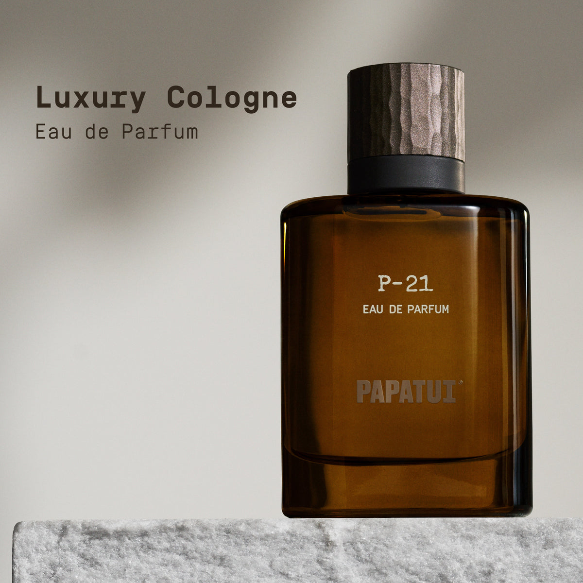 Amber cologne bottle labeled 'P-21 Eau de Parfum' by 'PAPATUI' on a neutral background