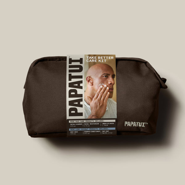 Papatui Holiday gift set facial care dopp kit with Dwayne the Rock Johnson on the belly band. Gift set includes men's hydrating facial cleanser, restoring facial moisturizer, and under eye patches and Papatui lush coconut mini body wash, shampoo and conditioner, and bar soap all in travel sizes.