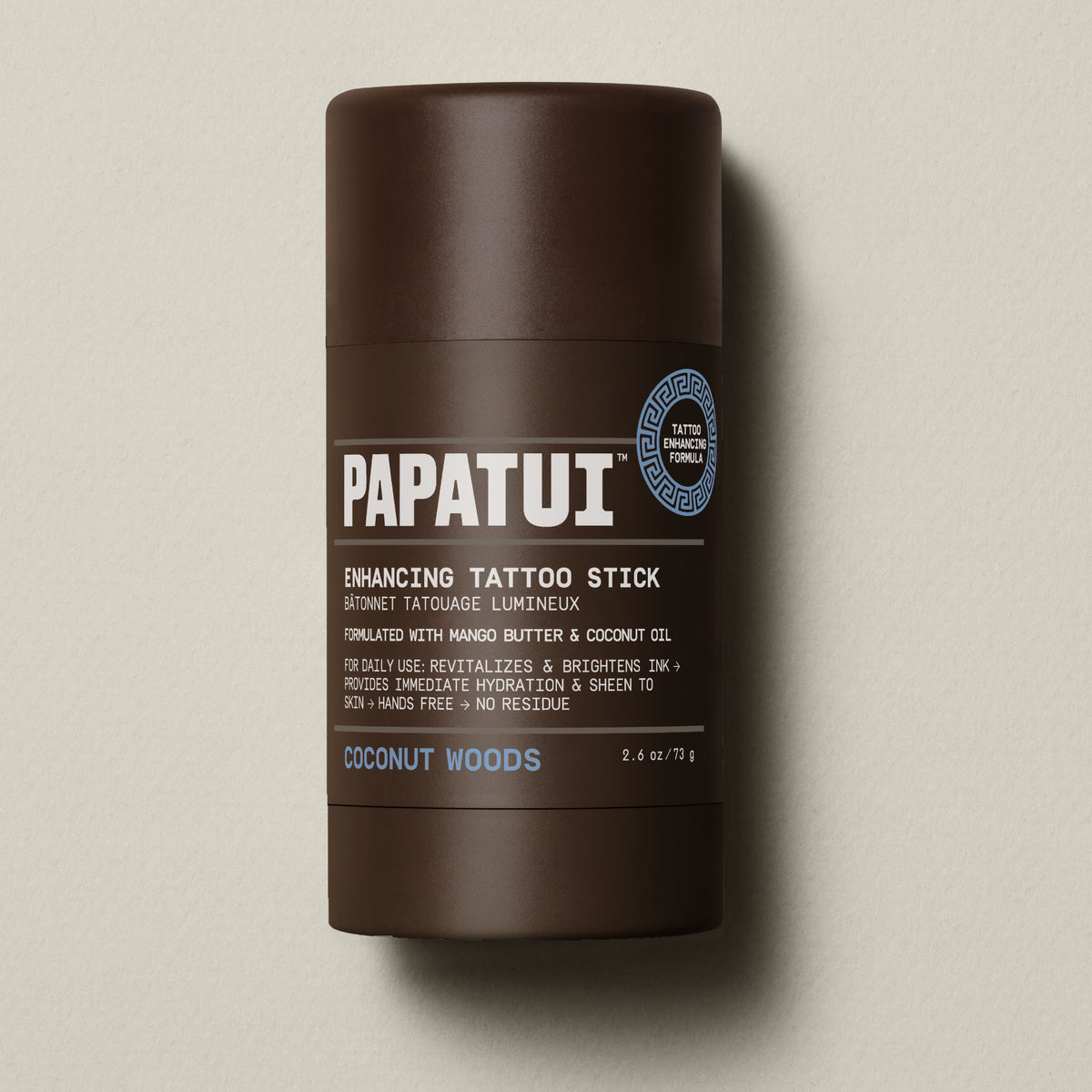 PAPATUI™ Enhancing Tattoo Stick Coconut Woods 2.6 oz stick standing alone on neutral background. Formulated with mango butter and coconut oil to hydrate skin and brighten tattoo ink with a signature coconut woods scent.