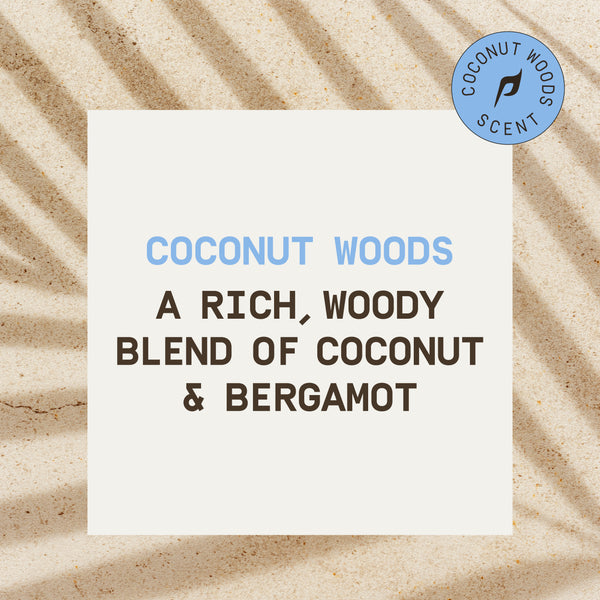 PAPATUI™ Coconut Woods scent card on textured sand background. Text reads: "A rich, woody blend of coconut & bergamot," highlighting the signature fragrance.
