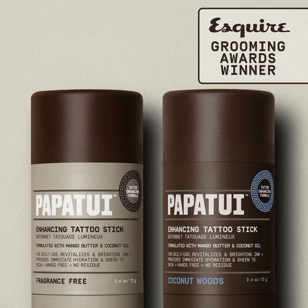 PAPATUI™ Enhancing Tattoo Stick Duo 
 featuring the Unscented and Coconut Woods 2.6 oz sticks displayed upright. Features Esquire Grooming Awards Winner badge. Products are designed to brighten tattoo ink and hydrate skin with mango butter and coconut oil.