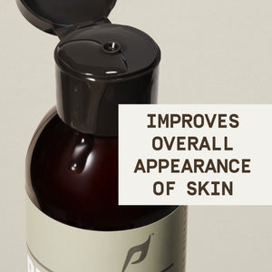 A close-up shot of the PAPATUI™ Unscented Rejuvenating Toner (6oz) bottle with its flip-top cap open, revealing the dispensing nozzle. A small drop of the lightweight formula is visible on the bottle’s sleek, amber surface. The minimalist beige label features the PAPATUI™ logo and branding. A bold text overlay on the right states,