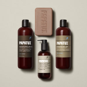 Group display of the full PAPATUI™ Ultimate Shower Bundle in Lush Coconut scent. Includes Hydrating Facial Cleanser, Lush Coconut Nourishing Shampoo + Conditioner, Lush Coconut Refreshing Body Wash, and Lush Coconut Enriching Big Bar Soap, all set against a soft beige background.