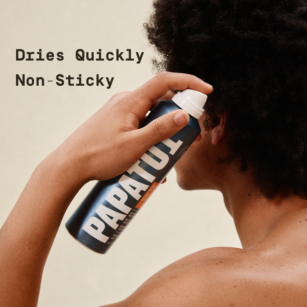 Person using a can of PAPATUI Acne Fighting body spray for men on bacne with text 'Dries Quickly Non-Sticky' on a beige background.