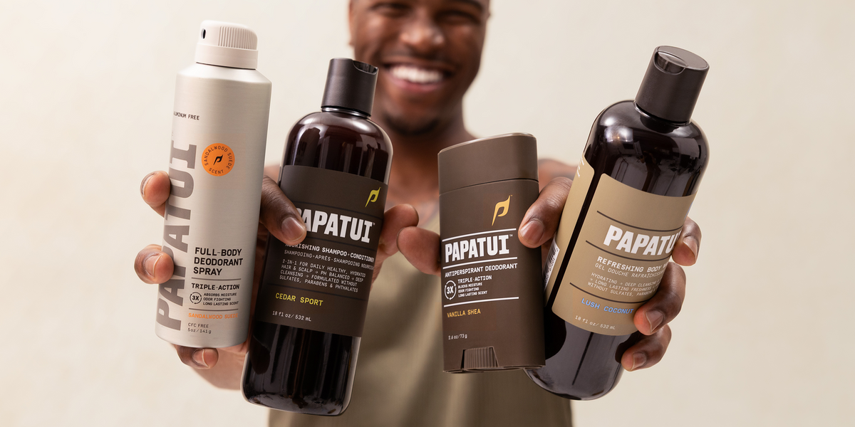Man holding assortment of PAPATUI products against a neutral background