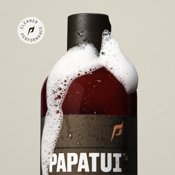 PAPATUI™ Nourishing Shampoo + Conditioner bottle shown with white foamy suds running down the cap and sides. A small "Cleaner Performance" badge is placed near the top left corner.