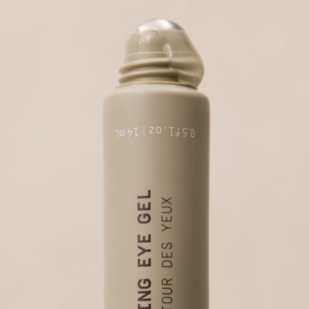Close-up of PAPATUI Awakening Eye Gel open with product coming out of applicator against a neutral background