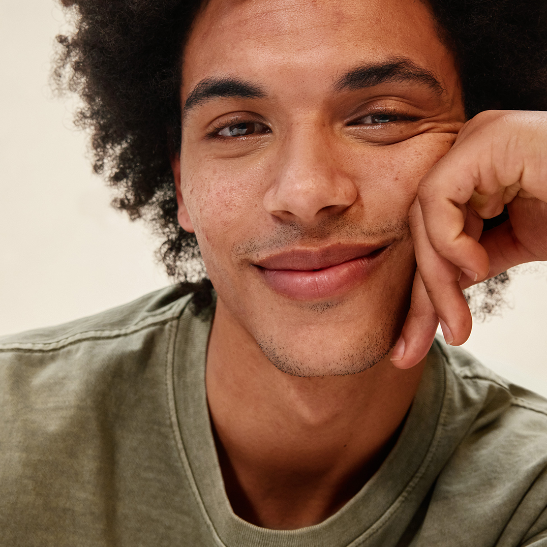 Man wearing a green shirt against a neutral background