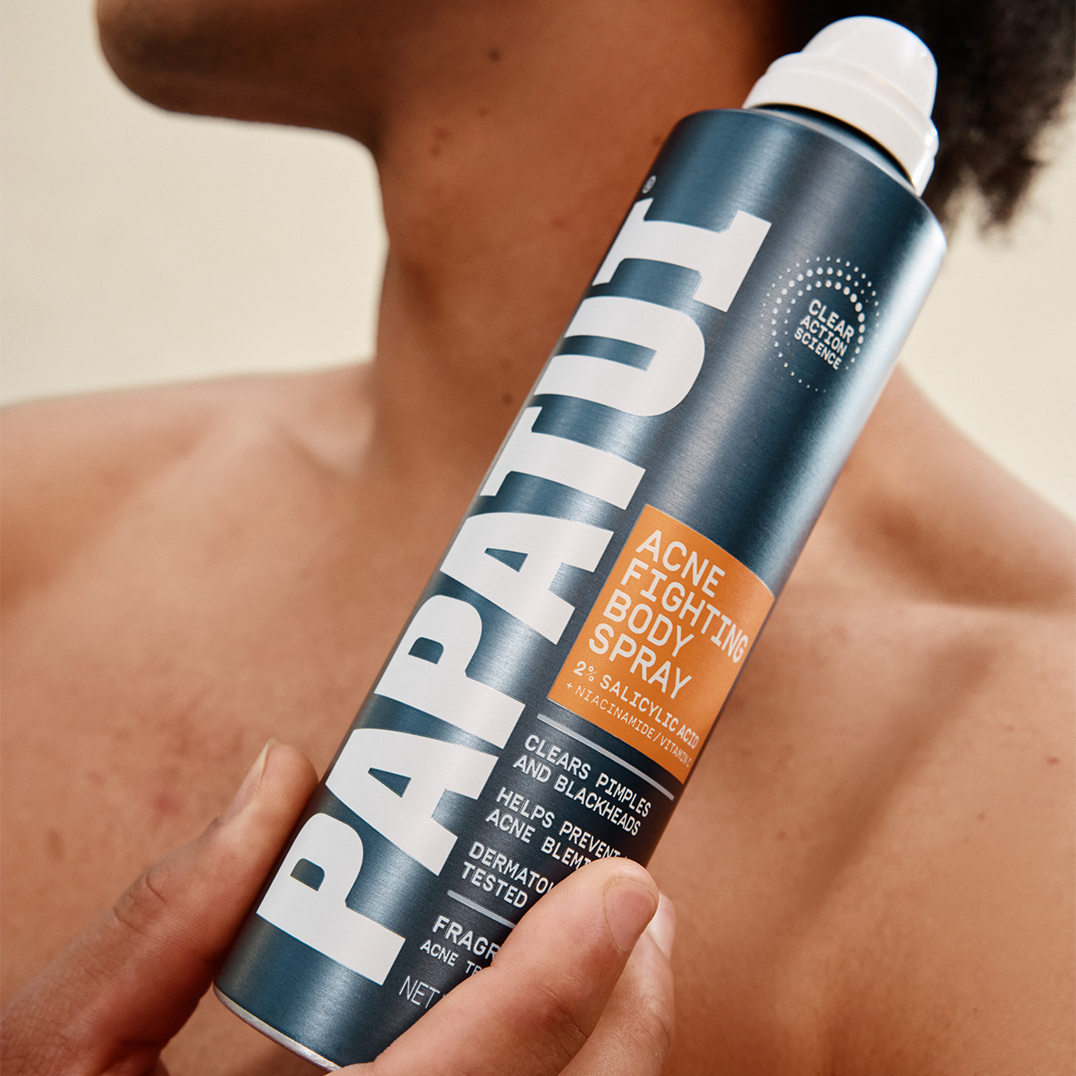 Man holding PAPATUI Acne Fighting Body Spray against a neutral background