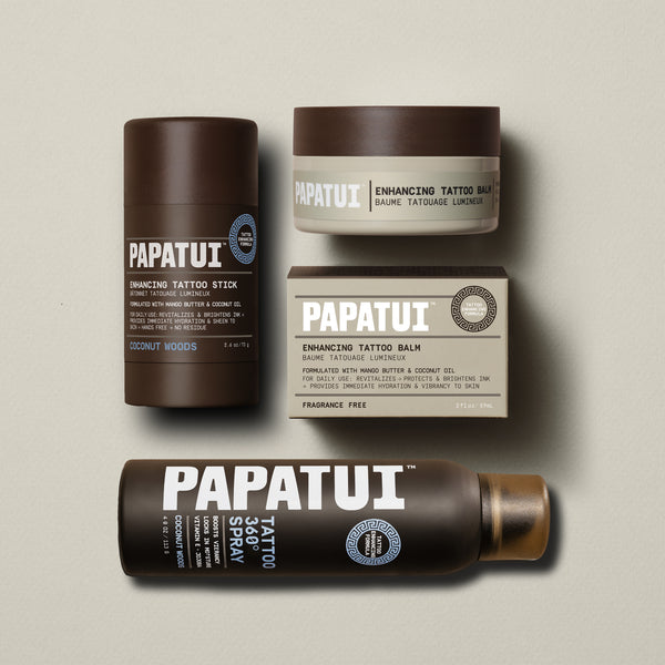 Papatui coconut woods scented tattoo stick and tattoo spray and unscented tattoo balm lined up on a plain beige background.