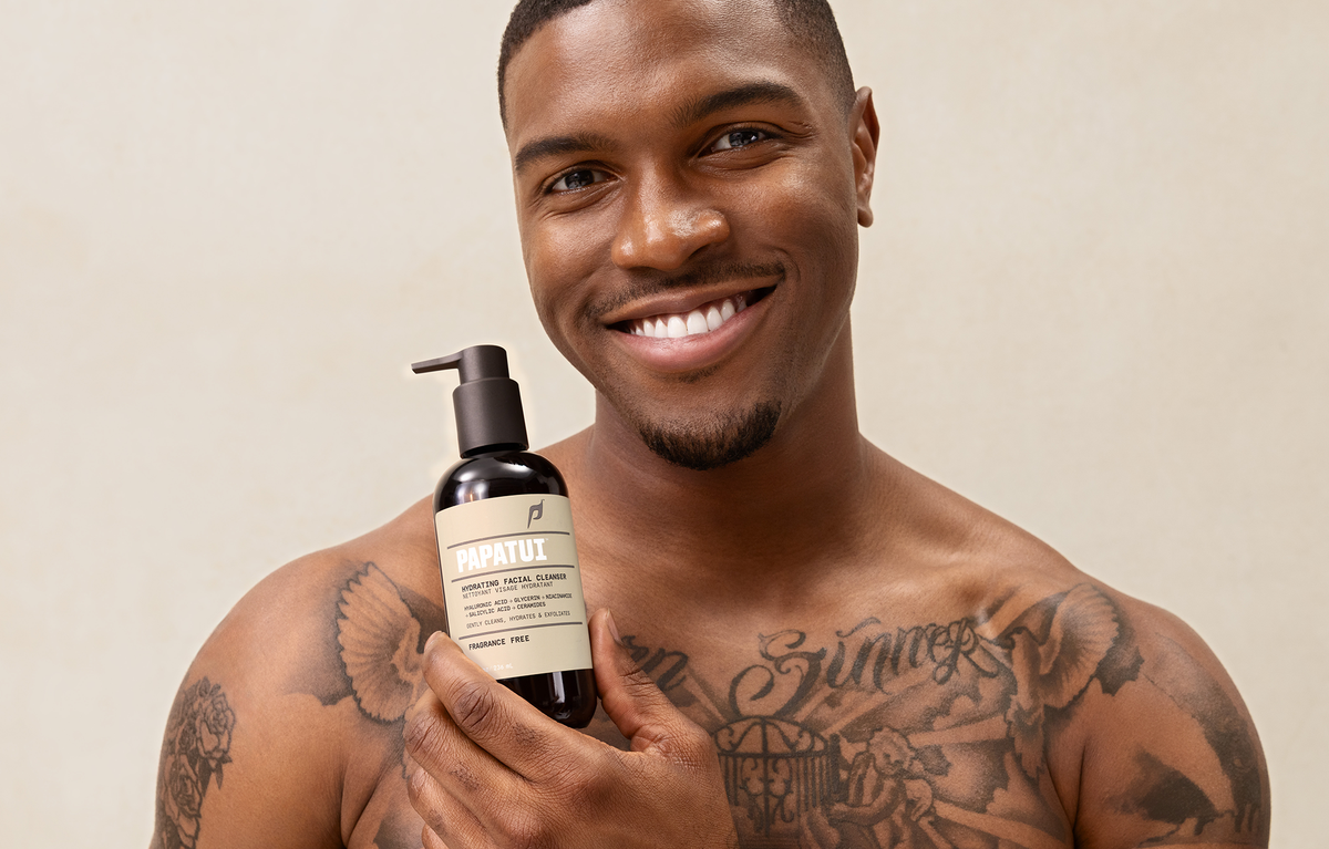 Man holding bottle of PAPATUI Hydrating Facial Cleanser against a neutral background