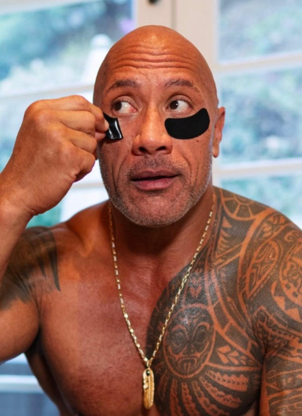 A shot of Dwayne Johnson using the PAPATUI™ Ageless Action Under Eye Patches to get bright and sexy eyes.