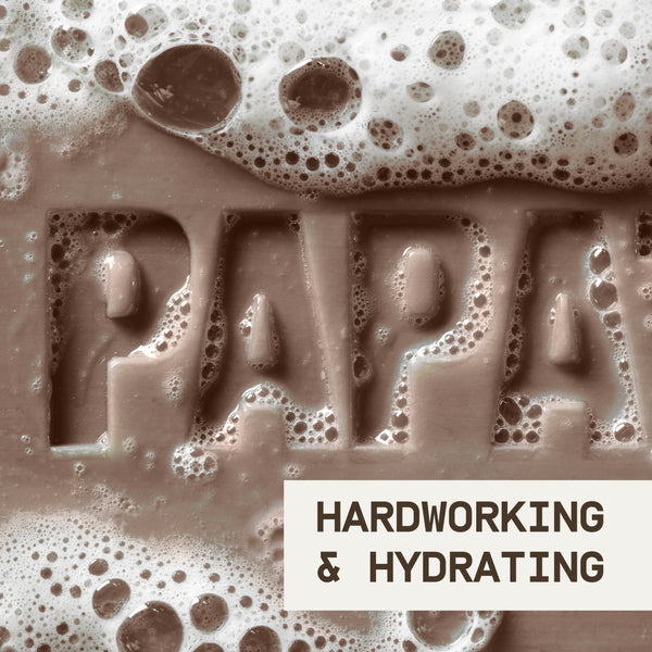 PAPATUI™ Lush Coconut Enriching Big Bar Soap 7oz hardworking and hydrating mens bar soap rich lather. Featuring Vitamin B3, mango butter, avocado oil, and ceramides for deep moisture and cleansing. The image shows a close-up of the embossed "PAPATUI" logo covered in foamy bubbles, emphasizing its luxurious, nourishing formula.