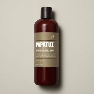 PAPATUI™ Refreshing Body Wash 18 fl oz in Vanilla Shea scent. The product is presented in an amber bottle with a beige minimalist label and black flip cap. Key label highlights include hydrating and exfoliating formula with long-lasting freshness. Claims sulfate-free, paraben-free, phthalate-free formulation. Neutral beige background.