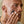 Dwayne Johnson applying PAPATUI™ Exfoliating Facial Scrub Unscented 4oz to his cheek. The dark gray scrub is spread smoothly on his skin as he gently rubs it in with his fingers. The close-up shot emphasizes the texture of the product and its exfoliating properties, with a neutral, softly lit background keeping the focus on his face and the scrub application.