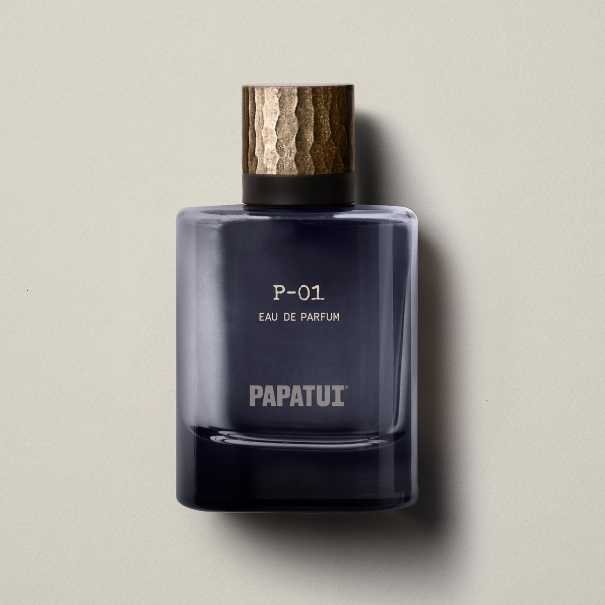 Blue cologne bottle labeled 'P-01 Eau de Parfum' by 'PAPATUI' on a neutral background