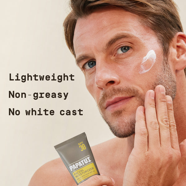 Man applying a tube of Papatui Men's daily moisturizer SPF with tan background with text reading "lightweight, non-greasy, no white cast." 