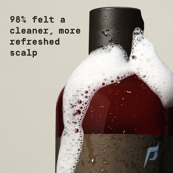 Bottle of shampoo with foamy head on a beige background, text indicating user feedback. - Papatui Shampoo and Conditioner