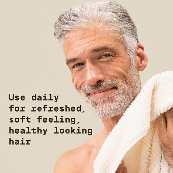 Man with gray hair and beard holding a towel, with text about hair care on a beige background - Papatui Shampoo and Conditioner