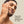 Man with a tattoo on his arm touching his face against a beige background with 