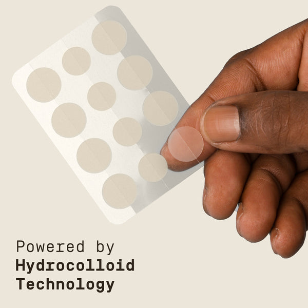 Hand holding a sheet of hydrocolloid PAPATUI Pimple Patches with text 'Powered by Hydrocolloid Technology' on a beige background.