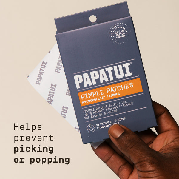 Papatui pimple patches packaging held by a hand on a beige background for men.