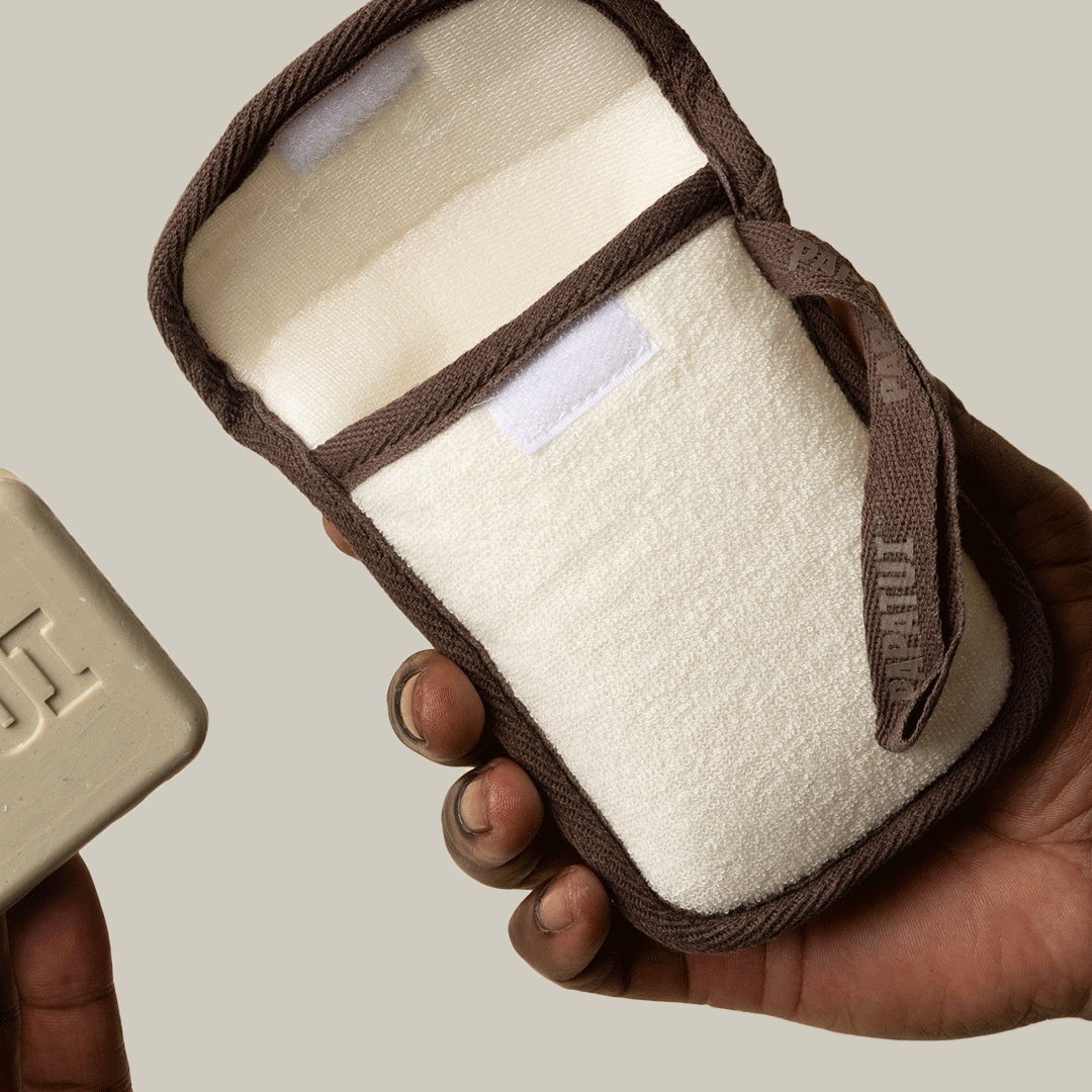 GIF of hand holding PAPATUI Exfoliating Body Scrubber and Big Bar Soap against a neutral background