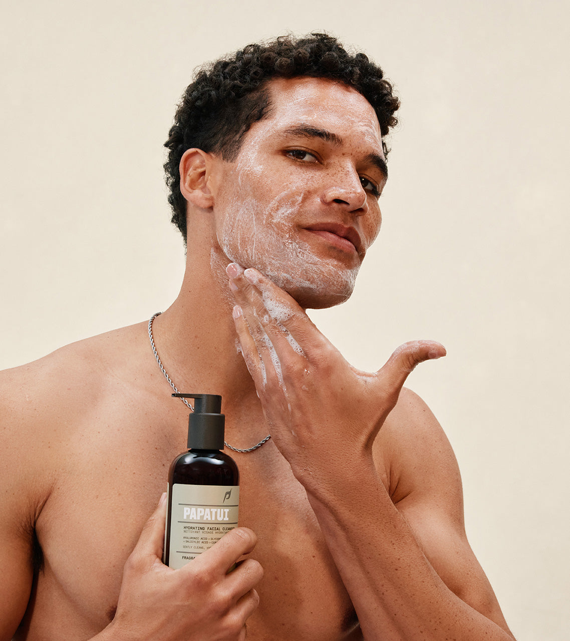 Man applying PAPATUI Hydrating Facial Cleanser to his face against a neutral background
