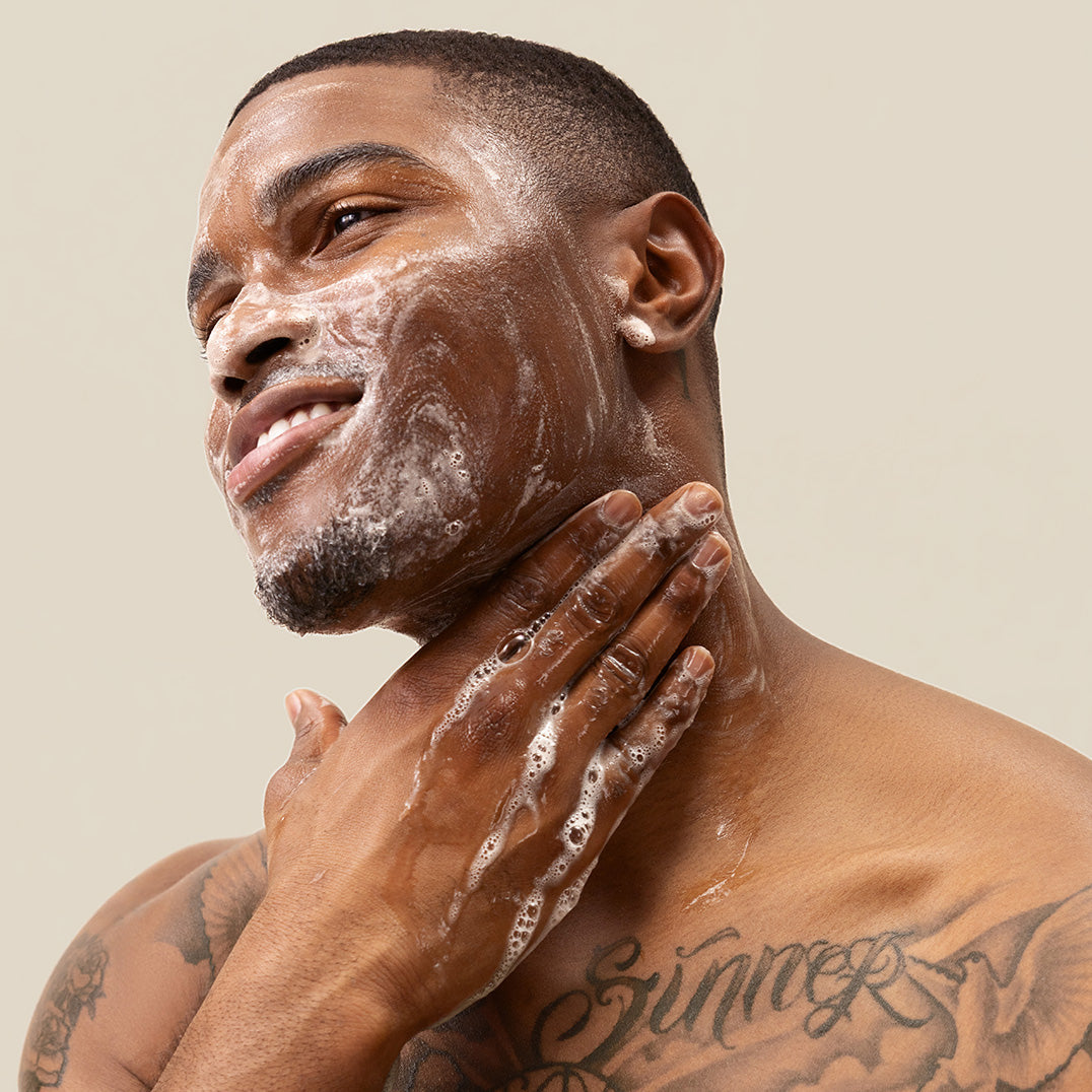 Man applying PAPATUI Hydrating Facial Cleanser to his face against a neutral background