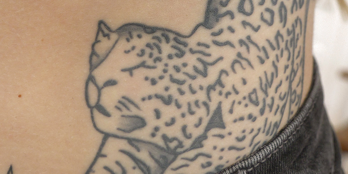 Close-up of a tattoo of a panther on a person's torso