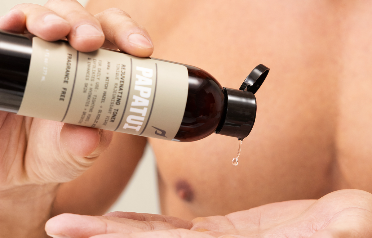 Man pouring PAPATUI Rejuvenating Toner into his hand against a neutral background