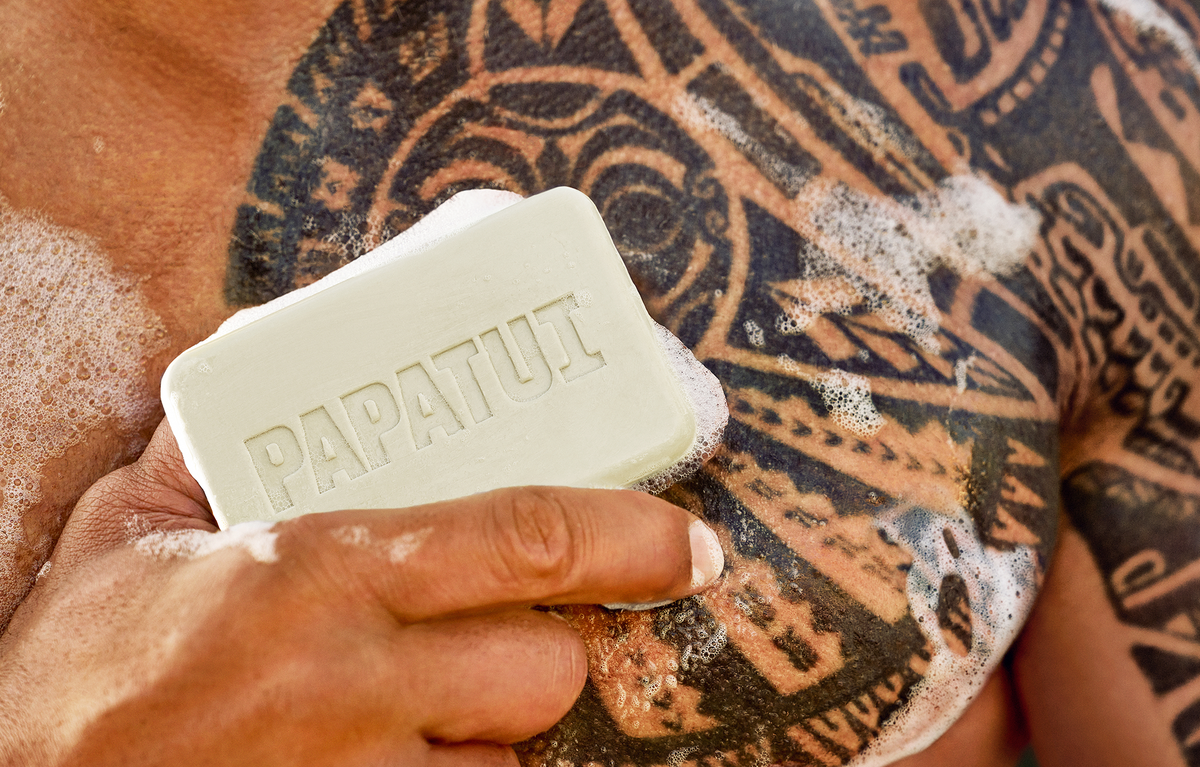 Close-up of Dwayne "The Rock" Johnson holding PAPATUI Bar Soap against his shirtless chest