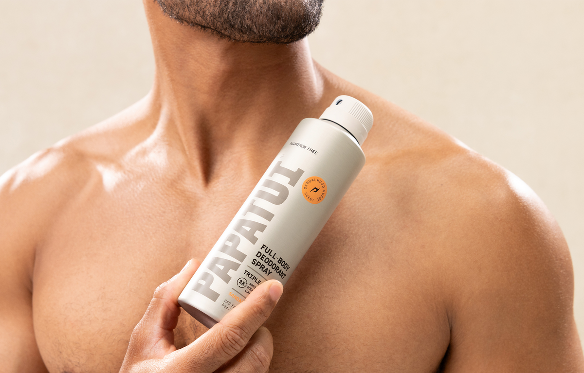 Man holding PAPATUI Full Body Deodorant Spray in Sandalwood Suede against a neutral background