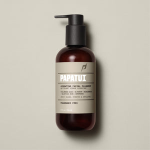 A bottle of PAPATUI Hydrating Facial Cleanser on a beige background. The brown bottle with a black pump dispenser has a label that mentions the product gently cleans, hydrates, and exfoliates, and is fragrance-free. The content volume is 8 fl oz or 236 ml.