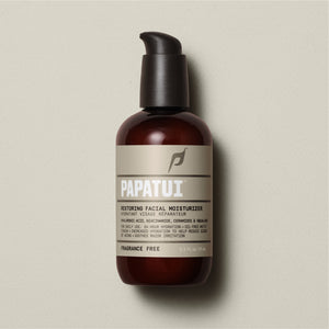Restoring Facial Moisturizer in a brown pump bottle with a black dispenser, against a beige background. The label states it contains hyaluronic acid, niacinamide, ceramides, and squalane. The bottle holds 3.3 fl oz or 97 ml of the product.
